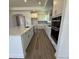 Well-lit kitchen boasting white cabinets, quartz countertops, stainless steel appliances, and wood flooring at 133 Oban Dr, Homesite 151, Sanford, NC 27330