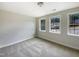A bright bedroom with neutral walls and carpet features three windows for ample light at 135 N Ridge View Way, Franklinton, NC 27525