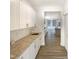 Butler's pantry featuring granite countertops, white cabinets, and stainless sink at 135 N Ridge View Way, Franklinton, NC 27525