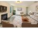 Bright living room with a cozy fireplace, neutral furniture, and large windows at 135 N Ridge View Way, Franklinton, NC 27525