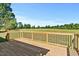 Wooden back deck with black metal railings overlooking an expansive field at 1467 Antioch Church Rd, Timberlake, NC 27583