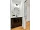 Well-lit half bath with a modern vanity, decorative mirror, and stylish fixtures, close to the hallway at 1467 Antioch Church Rd, Timberlake, NC 27583