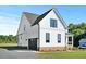 Side exterior elevation of a two-story white farmhouse with a black garage door at 1467 Antioch Church Rd, Timberlake, NC 27583