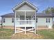View of the house's back porch with vinyl siding and an open grassy area at 182 Inverness St, Zebulon, NC 27597