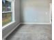 A carpeted room with a large window that provides natural light at 182 Inverness St, Zebulon, NC 27597