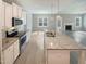 Modern kitchen with granite countertops, stainless appliances, and a view to the Gathering room at 182 Inverness St, Zebulon, NC 27597