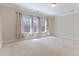 Spacious bedroom featuring three large windows with coverings and neutral carpeting at 1922 Pattersons Mill Rd, Durham, NC 27703