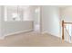 Hallway with carpeted floors, chandelier, and view to staircase at 1922 Pattersons Mill Rd, Durham, NC 27703
