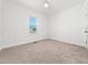 Cozy bedroom with neutral carpet, white walls, and a large window allowing natural light at 20 Wildflower Ln, Franklinton, NC 27525