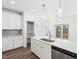 Open kitchen with stainless steel dishwasher, white cabinets, island with sink, and pantry at 20 Wildflower Ln, Franklinton, NC 27525