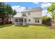 Spacious backyard featuring a screened-in porch, lush green lawn, and mature trees at 2017 Ollivander Dr, Cary, NC 27519