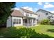 Backyard featuring a screened porch, patio, and well-manicured lawn surrounded by mature trees at 2017 Ollivander Dr, Cary, NC 27519