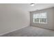 Neutrally decorated carpeted bedroom featuring a window with blinds at 2017 Ollivander Dr, Cary, NC 27519