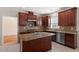 Gourmet kitchen features granite countertops, cherry cabinetry, stainless steel appliances, and a tile backsplash at 2017 Ollivander Dr, Cary, NC 27519