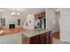 Open kitchen with granite island, stainless appliances, cherry cabinets and a view of the living room and fireplace at 2017 Ollivander Dr, Cary, NC 27519