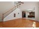 Bright living room featuring hardwood floors, staircase, and open access to a kitchen with dark cabinets at 2017 Ollivander Dr, Cary, NC 27519