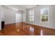 Bright living room featuring hardwood floors, large windows, and neutral paint providing ample natural light at 2017 Ollivander Dr, Cary, NC 27519