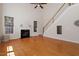 Living room with fireplace, hardwood floors, a staircase, and natural light creating a bright and inviting atmosphere at 2017 Ollivander Dr, Cary, NC 27519