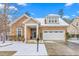 Inviting home showcasing a stone facade, well-kept lawn, and a convenient two-car garage during the snowy season at 208 Abigail Ln, Gibsonville, NC 27249