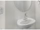 Close-up view of a bathroom pedestal sink with a round mirror and modern fixtures at 237 Daniel Ridge Rd, Wendell, NC 27591