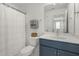 Bright bathroom features a shower with curtain, blue vanity and modern fixtures at 237 Daniel Ridge Rd, Wendell, NC 27591