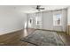 Bright living room features hardwood floors, large windows with curtains, a ceiling fan, and an exterior door at 237 Daniel Ridge Rd, Wendell, NC 27591