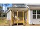 Exterior photo of the back porch with wood columns, railings, and staircase to the yard at 25 Arbor Dr, Youngsville, NC 27596