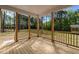 View of the wood planked, covered back porch with wood columns and railing overlooking the private backyard at 25 Arbor Dr, Youngsville, NC 27596