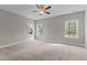 Spacious bedroom featuring plush carpet, ceiling fan, and multiple windows providing ample natural light at 25 Arbor Dr, Youngsville, NC 27596