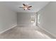 Bright bedroom with soft carpet, a ceiling fan, and a large window offering a view of the outdoors at 25 Arbor Dr, Youngsville, NC 27596