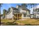 Rear exterior view of the home, with a wood porch and patio extending to the sprawling lawn at 25 Arbor Dr, Youngsville, NC 27596