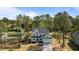 Aerial view of a light gray two-story home nestled among tall trees with a spacious front lawn at 25 Arbor Dr, Youngsville, NC 27596