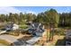 Aerial view of a charming gray home with a long driveway and lush trees creating a serene setting at 25 Arbor Dr, Youngsville, NC 27596