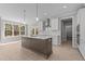 Bright kitchen with a central island, pendant lighting, stainless steel appliances, and a view to the backyard at 25 Arbor Dr, Youngsville, NC 27596