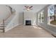 Cozy living room featuring a fireplace, staircase, and abundant natural light at 25 Arbor Dr, Youngsville, NC 27596