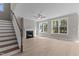 Bright living room boasts a fireplace, staircase, hardwood floors, and natural light from large windows at 25 Arbor Dr, Youngsville, NC 27596