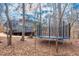 Backyard view with mature trees, showing a large trampoline, wood deck, and home at 260 Culbreth Rd, Chapel Hill, NC 27516