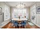 Bright dining room featuring a round table, blue chairs, hardwood floors, and large windows with shutters at 260 Culbreth Rd, Chapel Hill, NC 27516