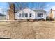 Charming white home featuring black shutters, brick chimney, and well-manicured front yard at 307 Gordon St, Roxboro, NC 27573