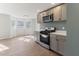 Modern kitchen with stainless steel appliances, gray cabinets, quartz counters, and luxury vinyl plank flooring at 307 Gordon St, Roxboro, NC 27573