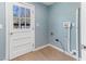 Bright laundry room features blue wood paneling, wood-look flooring, and a door to the exterior at 307 Gordon St, Roxboro, NC 27573