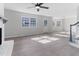 Bright and airy living room showcasing new flooring, large windows, and a painted fireplace with a ceiling fan at 307 Gordon St, Roxboro, NC 27573