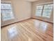 Empty bedroom showcasing hardwood floors and large windows that provide ample light at 318 N Estes Dr, Chapel Hill, NC 27514