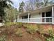 A beautiful exterior elevation with a long porch, brick foundation and mature landscaping at 318 N Estes Dr, Chapel Hill, NC 27514