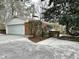Charming brick home with a two-car garage and inviting driveway, surrounded by mature trees and landscaping at 318 N Estes Dr, Chapel Hill, NC 27514