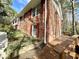 Two-story brick home with a garden, wooden deck, and red shutters, showcasing classic architectural details at 318 N Estes Dr, Chapel Hill, NC 27514