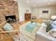 Cozy living room featuring a brick fireplace, light colored furniture and hardwood flooring at 318 N Estes Dr, Chapel Hill, NC 27514