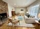 Spacious living room with hardwood floors, a brick fireplace, and stylish, comfortable furniture at 318 N Estes Dr, Chapel Hill, NC 27514