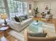 Bright and airy living room featuring hardwood floors, a modern sofa, and large windows at 318 N Estes Dr, Chapel Hill, NC 27514