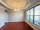 Elegant dining room with tray ceiling, hardwood floors, and a large window at 318 S Bend Dr, Durham, NC 27713